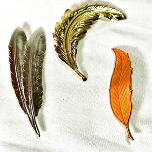 Elegant Feather Brooch Set in Silver, Gold, and Orange